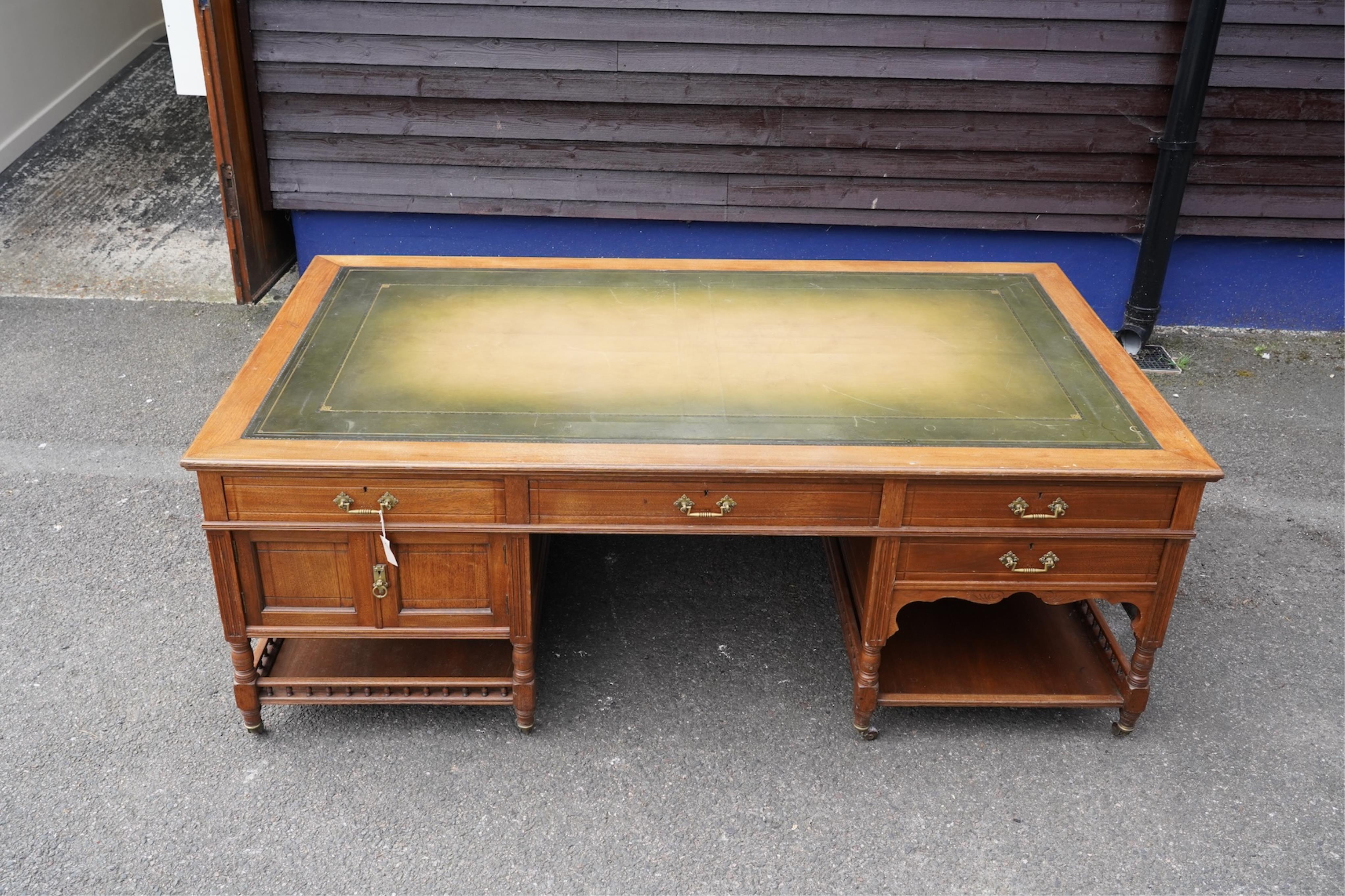 A late Victorian aesthetic movement walnut pedestal partner's desk with galleried undertier by repute from the British Library, width 212cm, depth 121cm, height 77cm. Condition - fair